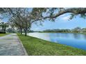 Peaceful waterfront view with walking path and mature trees alongside a canal at 5781 Girona Pl, Sarasota, FL 34238