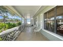 Front porch features white lattice, stone tile, and two white chairs at 603 Barnes Pkwy, Nokomis, FL 34275