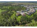 Aerial view of house nestled amongst large trees and green space at 6229 Rivo Lakes Blvd, Sarasota, FL 34241