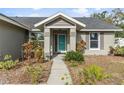 Front entry with teal door, surrounded by lush landscaping at 7117 Queen Palm Cir, Sarasota, FL 34243