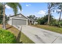 Gray house with a two-car garage and a nicely landscaped lawn at 7117 Queen Palm Cir, Sarasota, FL 34243