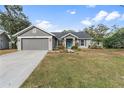 Newly renovated gray house with a teal front door and landscaped yard at 7117 Queen Palm Cir, Sarasota, FL 34243