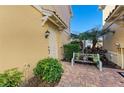 Private patio with brick pavers, greenery, and a quaint bench at 7879 Bergamo Ave, Sarasota, FL 34238