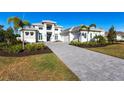 Two-story home with paver driveway & palm trees at 8497 Pavia Way, Bradenton, FL 34202