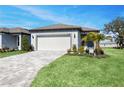 Charming single-story home features a two-car garage, manicured lawn, and mature landscaping at 9405 Ballaster Pointe Loop, Parrish, FL 34219