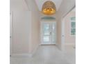 Inviting foyer features a decorative light fixture, arched doorway, and tile flooring at 1069 Harbour Cape Pl, Punta Gorda, FL 33983