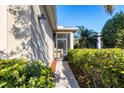 A cozy screened-in front porch with ample greenery around the walkway at 11938 Tempest Harbor Loop, Venice, FL 34292