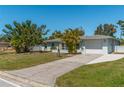 Ranch style home with attached garage and mature landscaping at 134 Rotonda Cir, Rotonda West, FL 33947