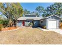 Newly painted house with a red door and well-manicured landscaping at 2037 Linwood Way, Sarasota, FL 34232