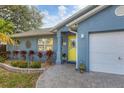 Front entrance with yellow door, landscaping, and paver walkway at 2207 22Nd W St, Bradenton, FL 34205