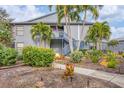 Gray condo building with stairs, landscaping, and palm trees at 2728 71St Street W Ct # 2078, Bradenton, FL 34209