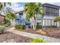 Gray condo building with stairs, landscaping, and palm trees at 2728 71St Street W Ct # 2078, Bradenton, FL 34209