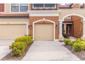 Tan townhome with double garage and manicured landscaping at 284 Crew Ct, Sarasota, FL 34243