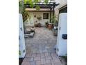 A paved courtyard with potted plants and a pergola at 3455 Anglin Dr, Sarasota, FL 34242