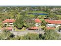 Aerial view of condos with red tile roofs and verdant grounds near a pond and golf course at 3500 El Conquistador Pkwy # 119, Bradenton, FL 34210