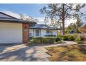 Front view of a white house with brick accents and a landscaped walkway at 3762 San Luis Dr, Sarasota, FL 34235