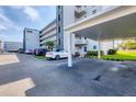 Exterior view of condo building with covered parking, manicured lawns, and landscaping at 3880 Ironwood Ln # 408E, Bradenton, FL 34209