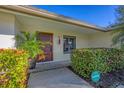 Well-maintained front entrance with a modern wooden door and landscaping at 419 Partridge Cir, Sarasota, FL 34236