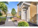 Inviting front entrance of a two-story home, surrounded by lush landscaping and serene lake view at 5711 Soldier Cir # 204, Sarasota, FL 34233