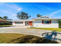 Single story home with a long driveway and mature trees at 617 Whitfield Ave, Sarasota, FL 34243