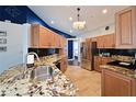 Modern kitchen with granite countertops, stainless steel appliances, and wood cabinets at 6589 Fairway Gardens Dr, Bradenton, FL 34203