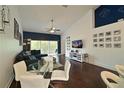 Open living area with dark hardwood floors, sectional sofa, and a dining area at 6589 Fairway Gardens Dr, Bradenton, FL 34203