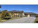 Front view of the house with a paved driveway and mature landscaping at 7020 Sena Rd, North Port, FL 34291