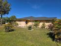 Side view of the house showcasing its stucco exterior and hurricane shutters at 7020 Sena Rd, North Port, FL 34291