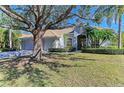 Single-story home with a large oak tree in the front yard and a two-car garage at 7215 Treymore Ct, Sarasota, FL 34243