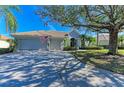 Single-story home with a two-car garage and mature landscaping at 7215 Treymore Ct, Sarasota, FL 34243