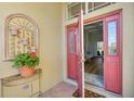 Inviting coral front door opens to reveal the home's interior at 7302 Deer Crossing Ct, Sarasota, FL 34240