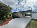 Tan house with carport and landscaped yard at 8585 Cristobal Avenue, North Port, FL 34287