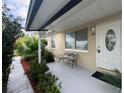 House entrance with a bench and potted plants at 8585 Cristobal Avenue, North Port, FL 34287