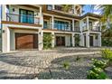 Modern home exterior with paver driveway and tropical landscaping at 107 Maple Ave, Anna Maria, FL 34216