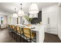 Spacious kitchen with white cabinets, island, and herringbone floors at 107 Maple Ave, Anna Maria, FL 34216