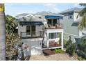 Two-story home with a white exterior, two balconies, and a basketball hoop at 110 46Th St, Holmes Beach, FL 34217