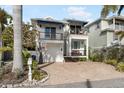 Two-story home with white exterior, balconies, and brick driveway at 110 46Th St, Holmes Beach, FL 34217