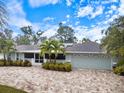 Beautiful single Gathering home with well manicured lawn, brick paver driveway, a screened porch, and two car garage at 121 Holly Ave, Sarasota, FL 34243