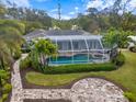 Aerial view of screened pool with brick pavers, mature tropical landscaping and custom design at 121 Holly Ave, Sarasota, FL 34243