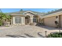 House exterior showcasing a paver driveway and two-car garage at 12471 Natureview Cir, Bradenton, FL 34212