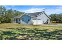 Gray sided home with two car garage and spacious yard at 13995 Mossy Hammock Ln, Myakka City, FL 34251