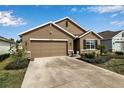 Tan house with brown garage door, landscaping, and a stone facade at 17741 Canopy Pl, Bradenton, FL 34211