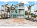 Two-story house with light teal exterior, garage, and palm trees at 203 69Th St # A, Holmes Beach, FL 34217