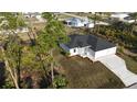 An aerial view of a well-manicured lawn of a single-Gathering home with three-car garage at 2323 Zuyder Ter, North Port, FL 34286