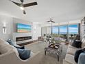 Modern living room showcasing a fireplace, comfortable seating, and sliding glass doors to an outdoor patio with ocean vistas at 3060 Grand Bay Blvd # 124, Longboat Key, FL 34228