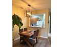 Bright dining area with wooden table and chairs, view into kitchen at 3453 Parkridge Cir # 18-101, Sarasota, FL 34243