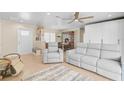 Living room with gray reclining sofas, wood shelving, and tiled floors at 372 Tihami Rd, Venice, FL 34293