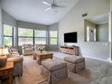 Open living room boasts large windows, a ceiling fan, a comfy couch and a large TV at 3822 Ironwood Ct, Sarasota, FL 34243