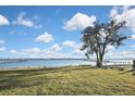 Scenic waterfront view with lush green grass and a tree at 4511 7Th Street E Ct, Ellenton, FL 34222