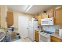 Well-lit kitchen featuring wood cabinets and white appliances at 4850 51St W St # 9106, Bradenton, FL 34210